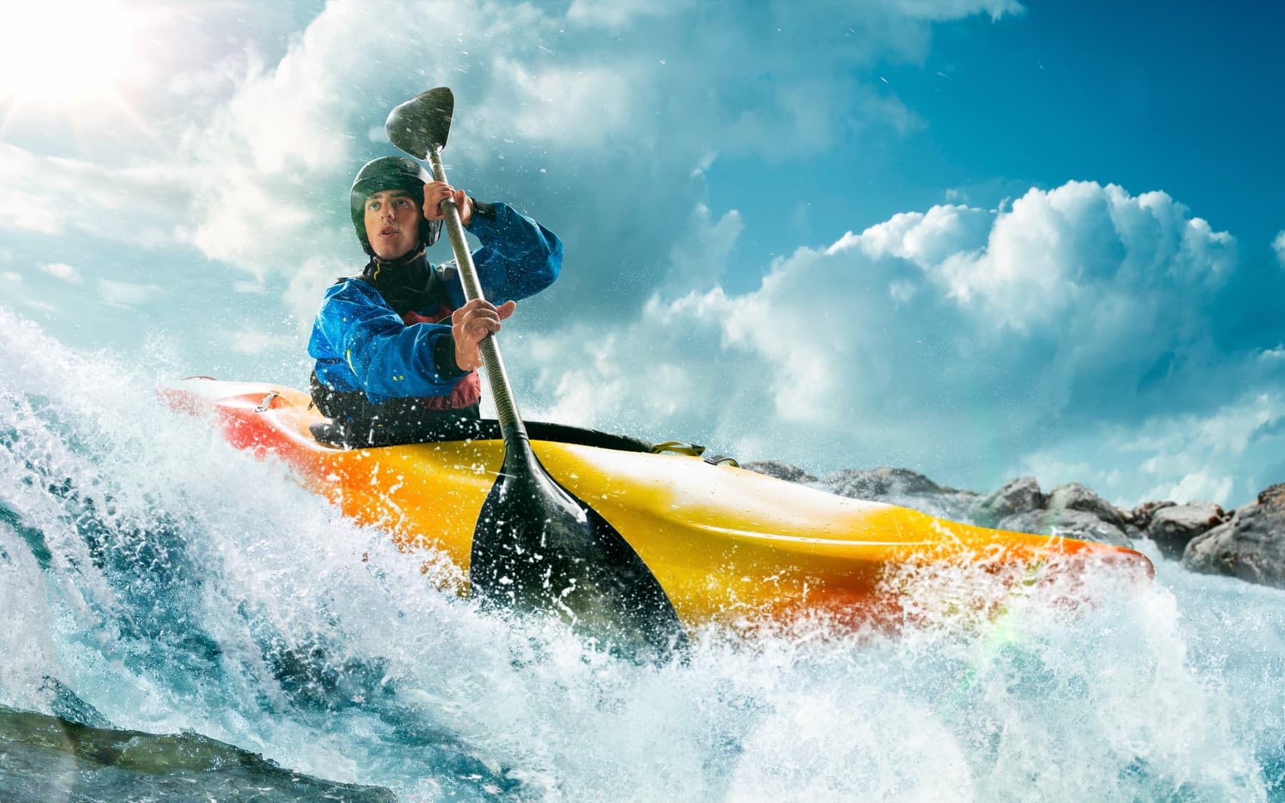 A paddler driving through whitewater